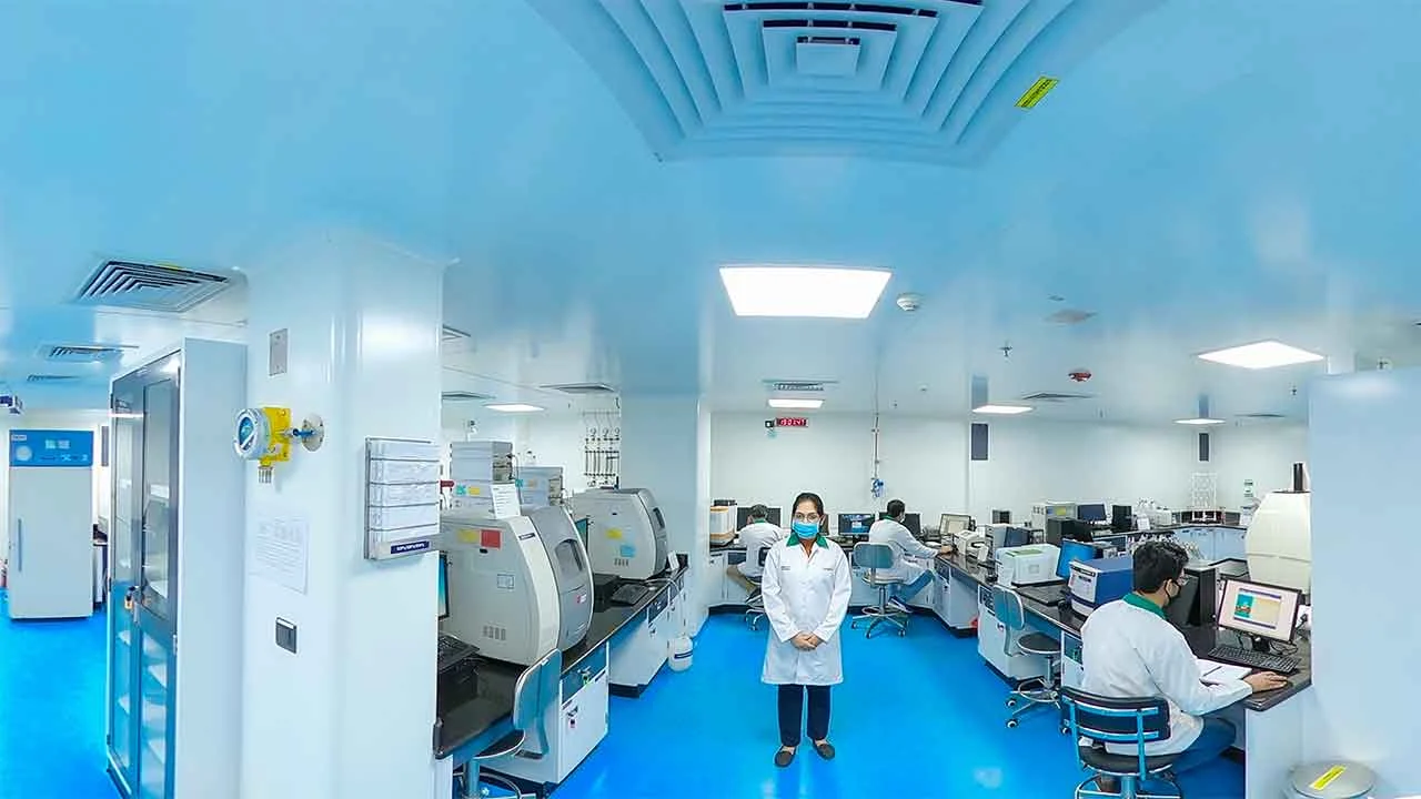 A quality control specialist in a lab coat and gloves meticulously inspecting finished gummy supplements, ensuring product safety and potency.